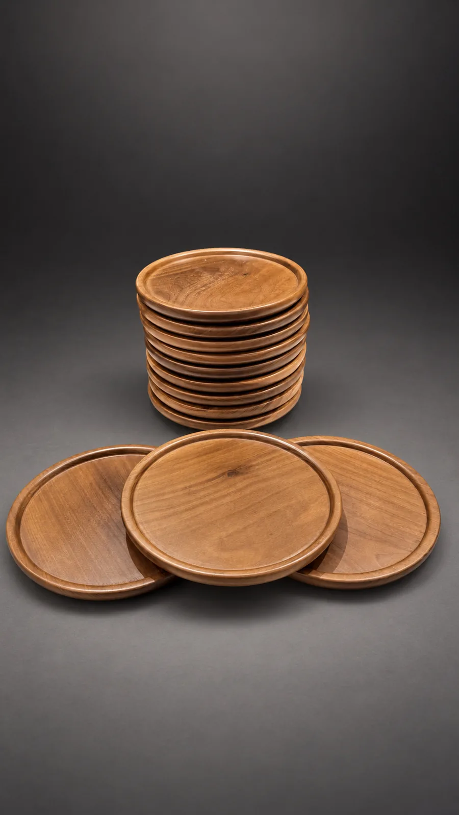 Platos playos de madera apilados, con tres apoyados adelante donde se ve la veta y el borde bajo